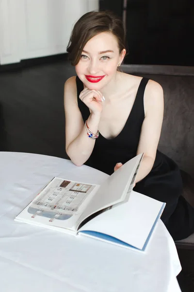 Charming woman with book at table