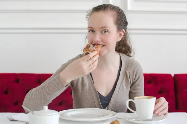 Mujer comiendo una taza de café croissant desayuno —  Fotos de Stock