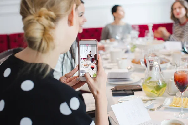 Mujer tomando fotos de teléfonos inteligentes en banquete — Foto de Stock