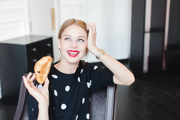 Charming woman eating bun — Stock Photo, Image