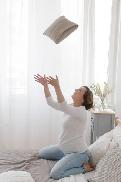 Mujer embarazada divirtiéndose con almohada — Foto de Stock