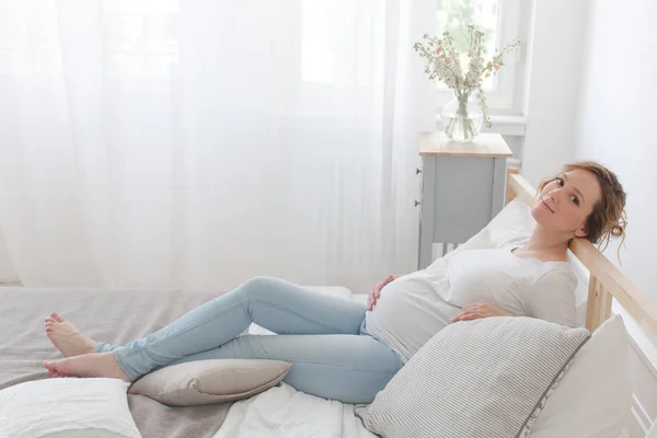 Terhes nő fekszik az ágyon — Stock Fotó
