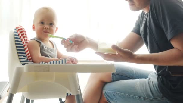 Vater füttert süßes Baby zu Hause — Stockvideo