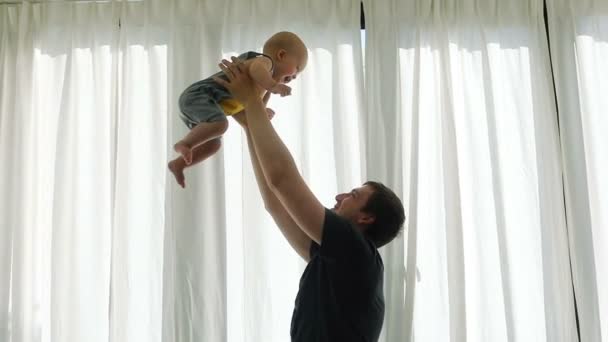 Молодой отец со своим маленьким ребенком играет — стоковое видео