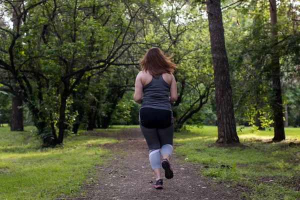 La mujer con sobrepeso vuelve a correr. Concepto de pérdida de peso — Foto de Stock