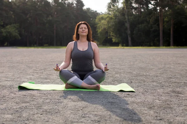 Plus tamaño chica meditando al aire libre yoga — Foto de Stock