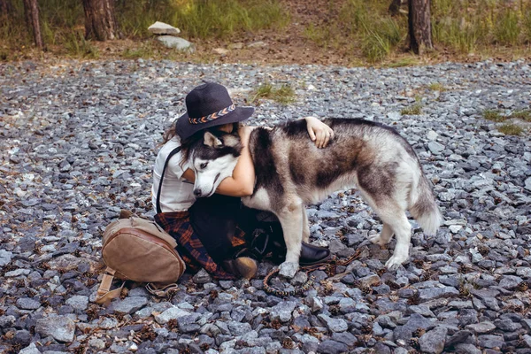 Kvinna som omfamnar med hund på stenar — Stockfoto