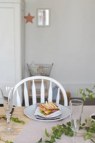 Тарелка с бутербродом на красиво сервированном столе — стоковое фото