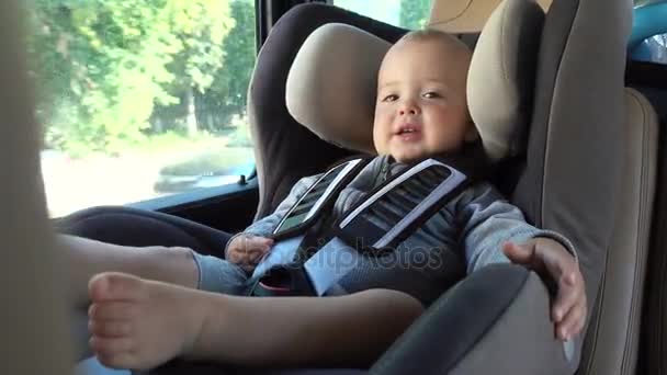 Pequeño bebé en silla elevadora en coche — Vídeos de Stock