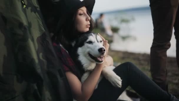 Mujer y lindo perro relajarse en la playa al atardecer — Vídeo de stock