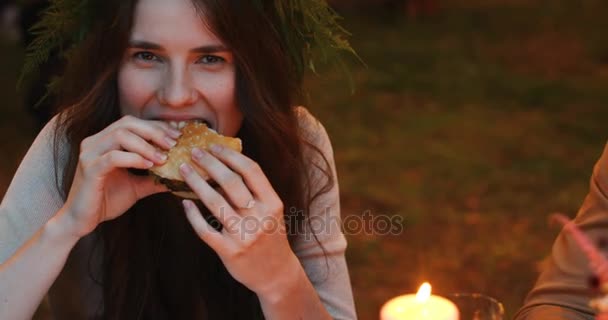 Задоволена жінка їсть гамбургер — стокове відео