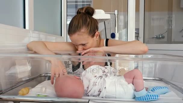 Woman playing with baby in cradle — Stock Video