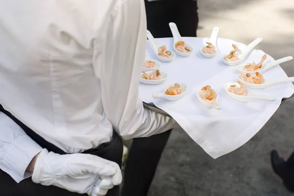 Garçom andando com aperitivos — Fotografia de Stock