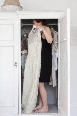Bir kadın bir elbise dolabında seçer.