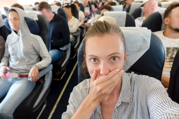 Испуганная женщина в самолете — стоковое фото