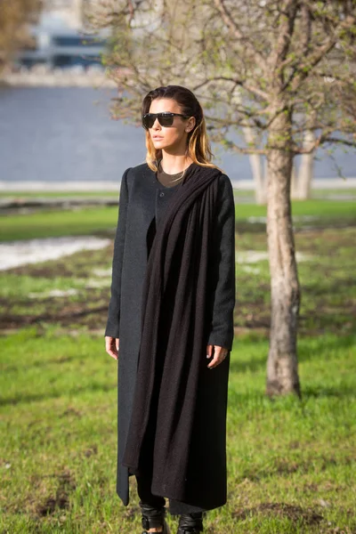 Flicka i svart kappa med en halsduk — Stockfoto