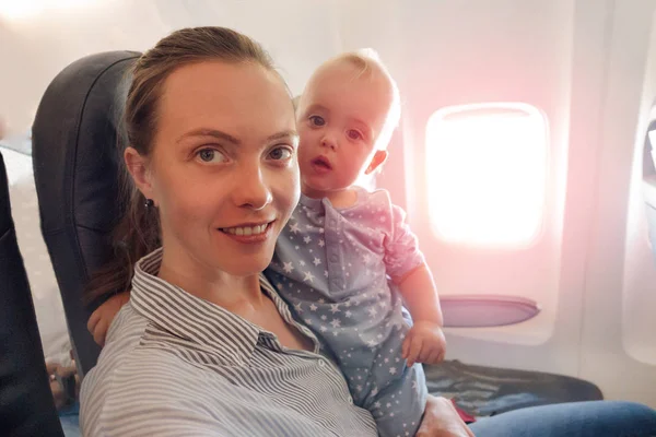 Μητέρα και το μωρό που ταξιδεύουν με αεροπλάνο ματιά στην κάμερα — Φωτογραφία Αρχείου