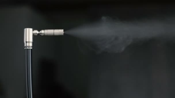 Mondstuk sprays vloeistof in damp zwarte achtergrond — Stockvideo
