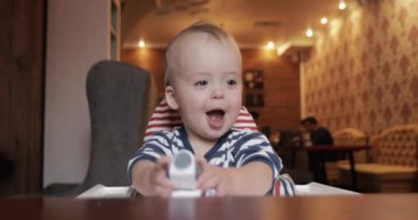 Bir yüksek sandalyede oturuyor araba ile oynayan çocuk