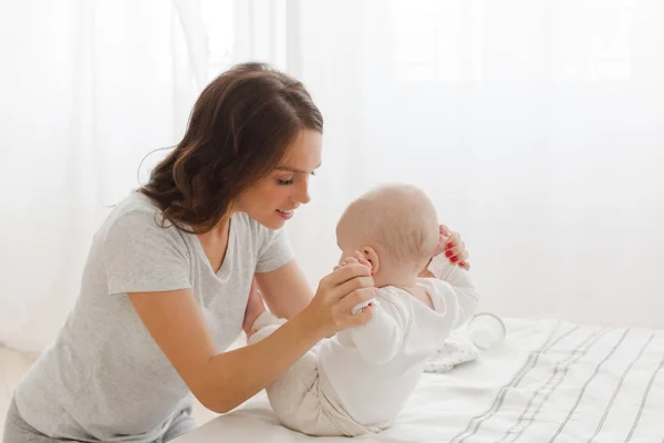 Mother helping child to sit — Stock Photo, Image