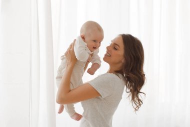 Anne bebek kollarında penceresi arka planını tutar