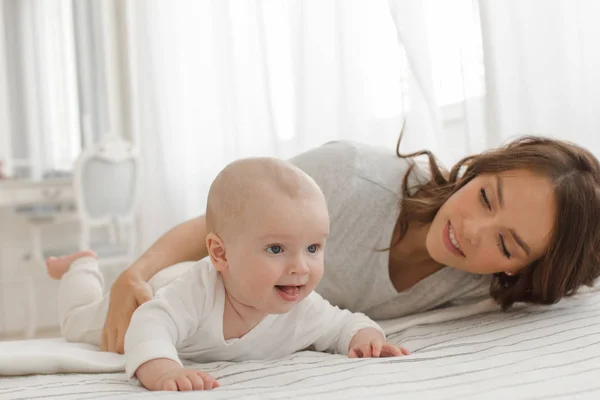 Madre e bambino che giocano e sorridono sul letto — Foto Stock