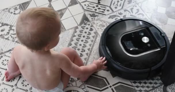 Мальчик и робот пылесос на полу — стоковое видео