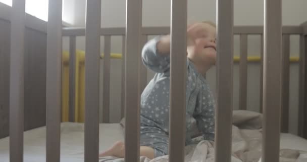 Bambino nella culla si guarda intorno e sorride — Video Stock