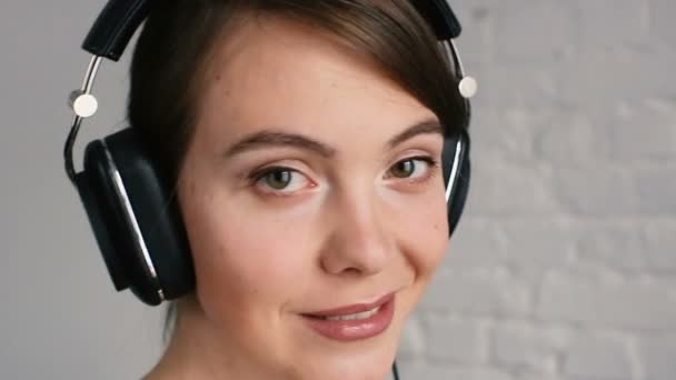 ヘッドフォンで音楽を聴く女性をクローズ アップ — ストック動画