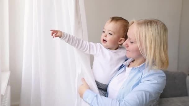 Madre con su bebé mirando a la ventana — Vídeo de stock