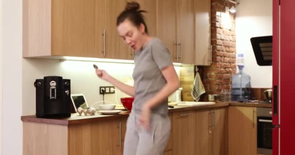 Happy woman in the kitchen sings and dances — Stock Video