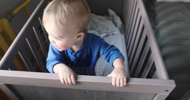 男の子が座っているし、ベビーベッドで恐怖視聴者を得る — ストック動画