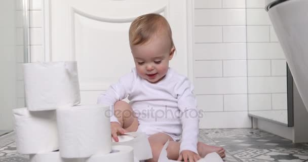 Niño jugando con papel higiénico sentado en el suelo — Vídeo de stock