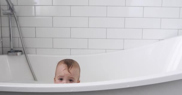 Pequeño niño se sienta en la bañera, los ojos — Vídeos de Stock