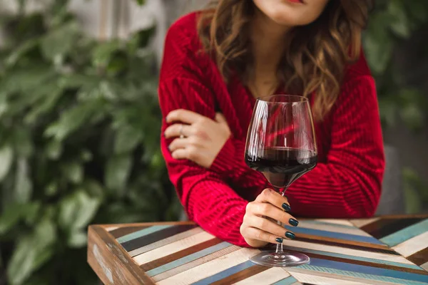 Uma menina está sentada com um copo de vinho — Fotografia de Stock