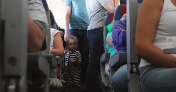 Baby pojke promenader längs korridoren av cockpit — Stockvideo