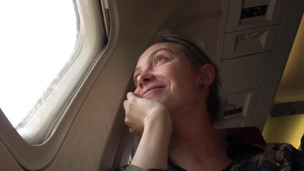 Woman at porthole in plane — Stock Video