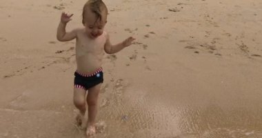 Kumsalda adamla çalışan küçük bebek