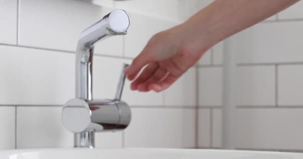 Mezclador abierto de mano femenina con agua en el baño — Vídeo de stock