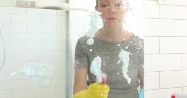 Женщина стирает зеркало в ванной — стоковое видео