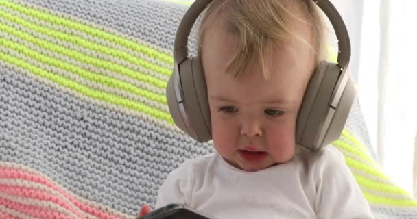 Dítě poslouchá sluchátka držící smartphone