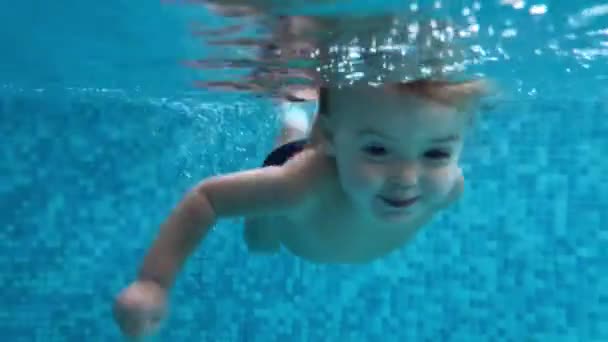 Yüzme havuzunda su altında dalış yürümeye başlayan çocuk — Stok video