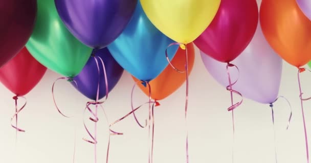 Красочные воздушные шары, машущие на белом фоне — стоковое видео