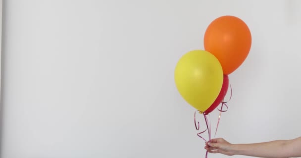 Kvinnans hand håller ballonger i en vit bakgrund — Stockvideo