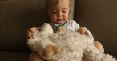 Yumuşak oyuncak kanepede oynayan erkek bebek