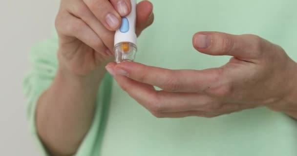 Flicka diabetiker punktera finger att mäta blod — Stockvideo