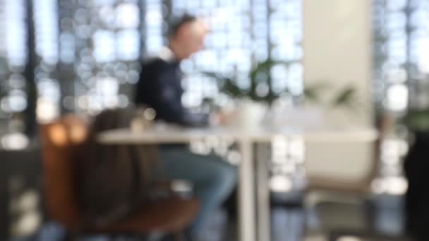 Man aan het werk op laptop aan tafel vervagen — Stockvideo