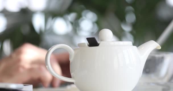 Teapot on background of male hands typing laptop — Stock Video