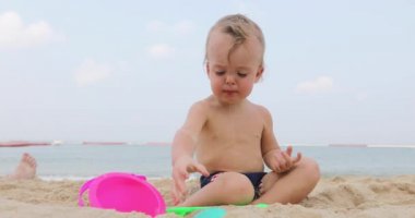 Kum plajındaki sevimli bebek