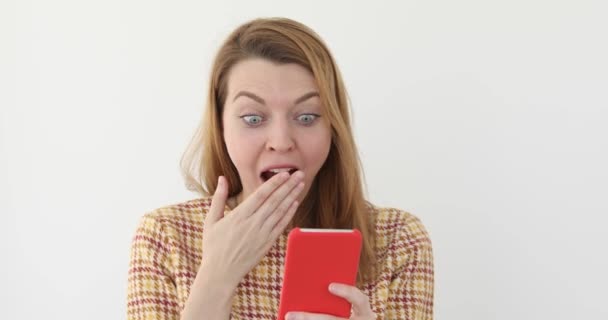 Menina bonita olha para o telefone móvel chocadoclose-up — Vídeo de Stock